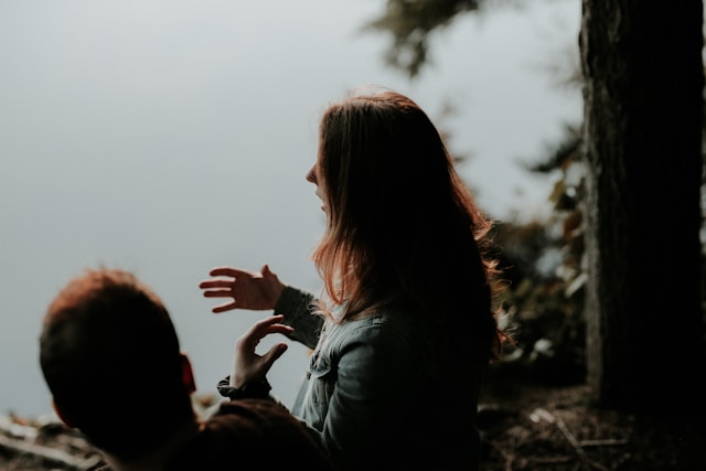 Foto van twee mensen die met elkaar in gesprek zijn in de natuur.
